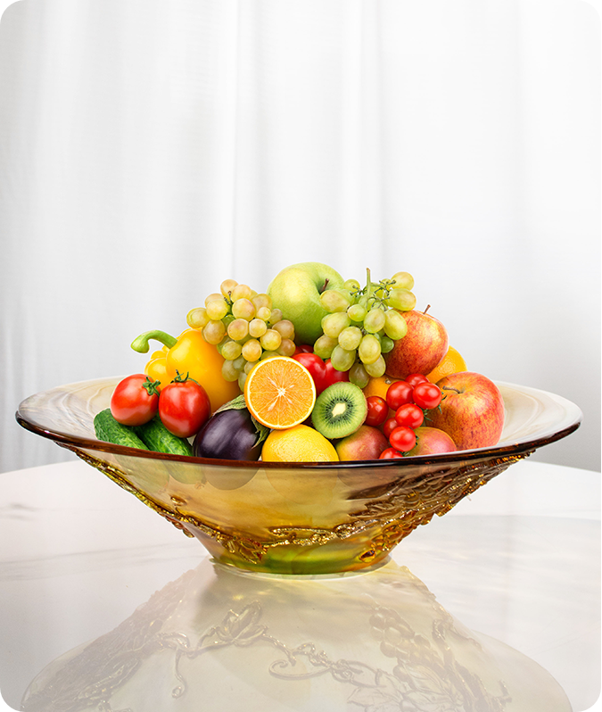 Một chiếc bình thủy tinh miệng rộng chất đầy trái cây